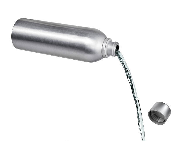 istock pouring liquid from a metal bottle on white background 610790586