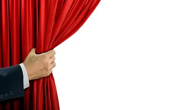 Hand opening stage red curtain over white