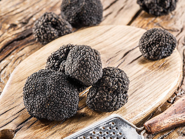 istock Black truffles on the old wooden table. 610840774