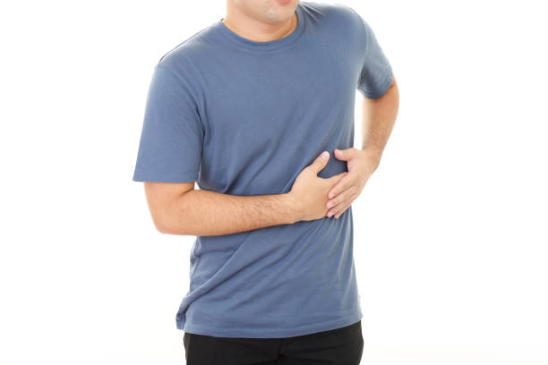 Man has abdominal pain Man has abdominal pain over white background rib cage stock pictures, royalty-free photos & images