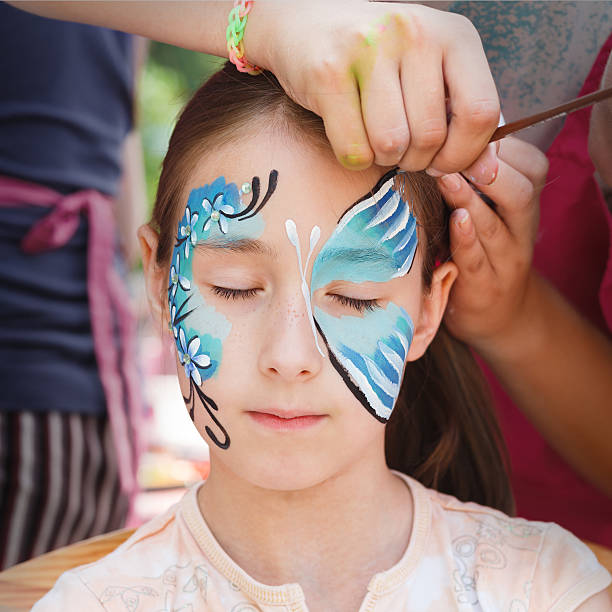 istock Female child face painting, making butterfly process 610843560