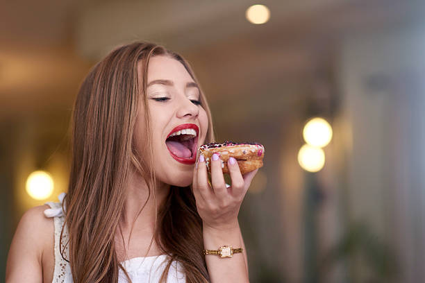 portrait of little girl licking blender with chocolate dough