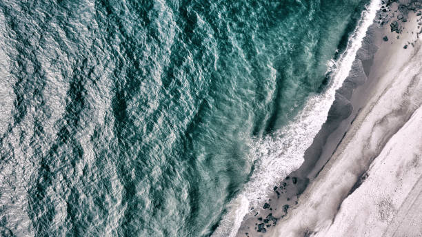 Sea and Shore The sea with waves and ripples and the shore with rocks. This image was photographed from above with a drone. north sea waves stock pictures, royalty-free photos & images