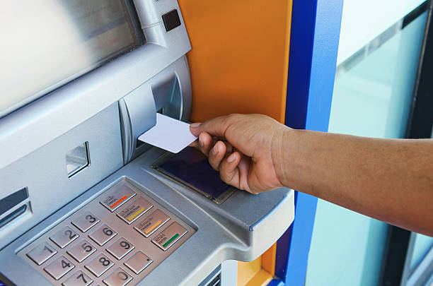 istock female hand inserting ATM card into ATM bank 610845242