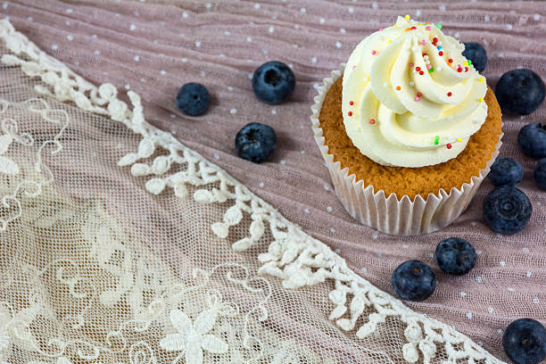 istock Usual vanilla cupcake with white cream with many blueberries 610845808