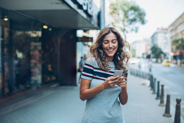 istock Smiling girl texting on the street 610846512