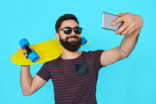 istock young handsome bearded hipster man makes selfie 610848476