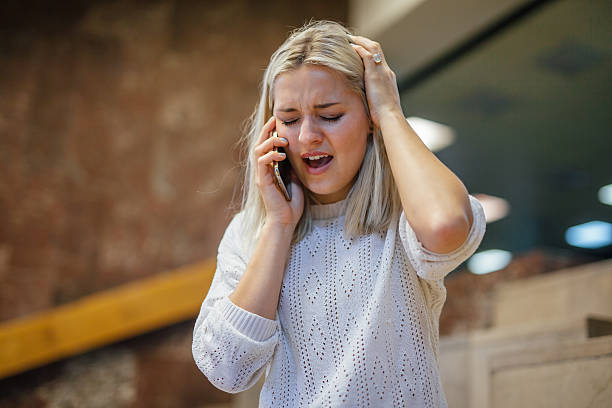 Shocked young woman is talking by the phone. stock photo