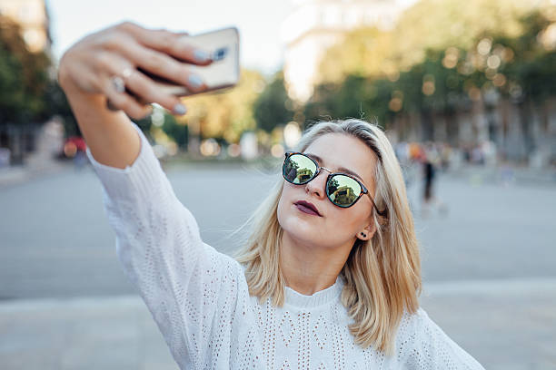 Young woman is taking a selfie by mobile phone. stock photo