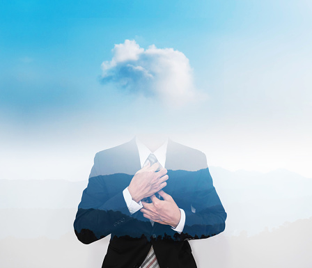 Double exposure businessman with cloud instead of head, on blue sky with silhouette mountains