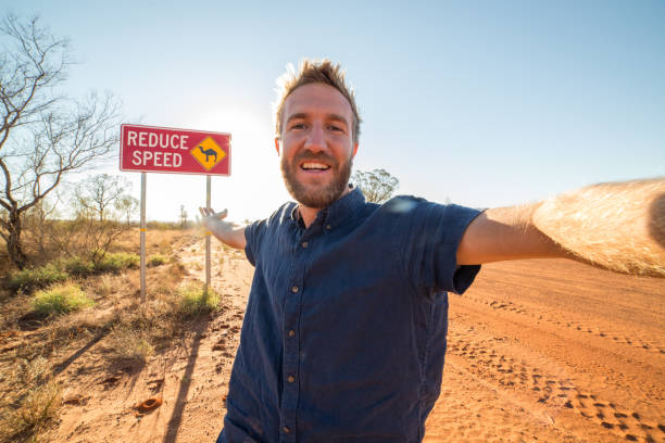 istock Selfie of young man standing by Camel warning sign 610854864