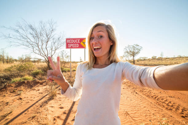 istock Young woman takes selfie with Camel warning sign 610855020