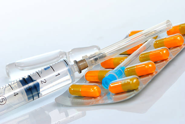 injection de pilules de seringue à aiguille - injecting capsule macro pill photos et images de collection
