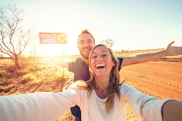 istock Young couple take selfie with camel crossing sign 610855366