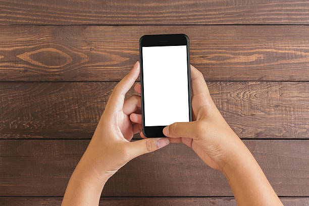 istock phone in woman hand showing white screen on wood table 610856092