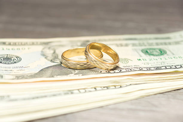 istock Wedding rings and cash 610857636