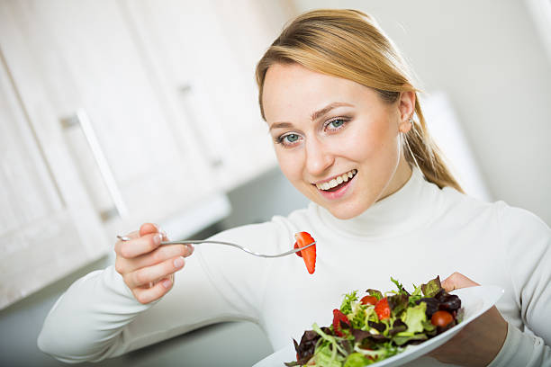 istock Happy girl with vegetable salad in kitchen 610857920