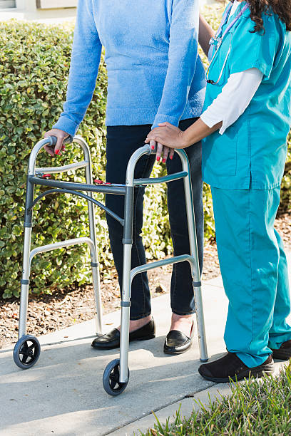 istock Cropped view of senior woman using walker with nurse 610857982
