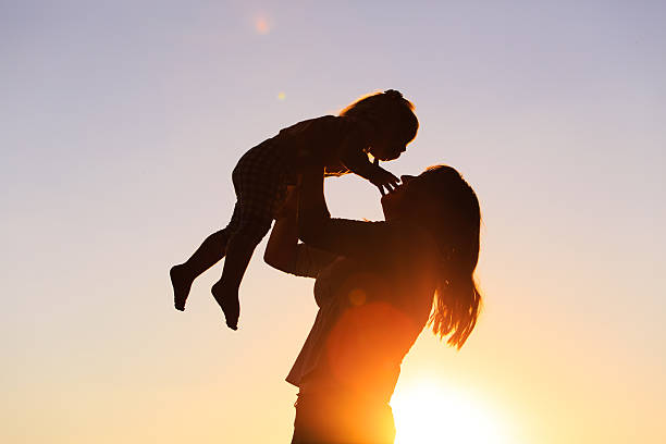 istock mother and little daughter play at sunset 610860916