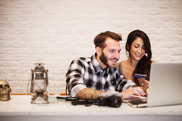 young couple in love planning a trip with laptop - airplane ticket ticket airplane internet imagens e fotografias de stock