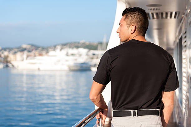 male crew member looking from yacht boat - men railing passenger ship shipping imagens e fotografias de stock