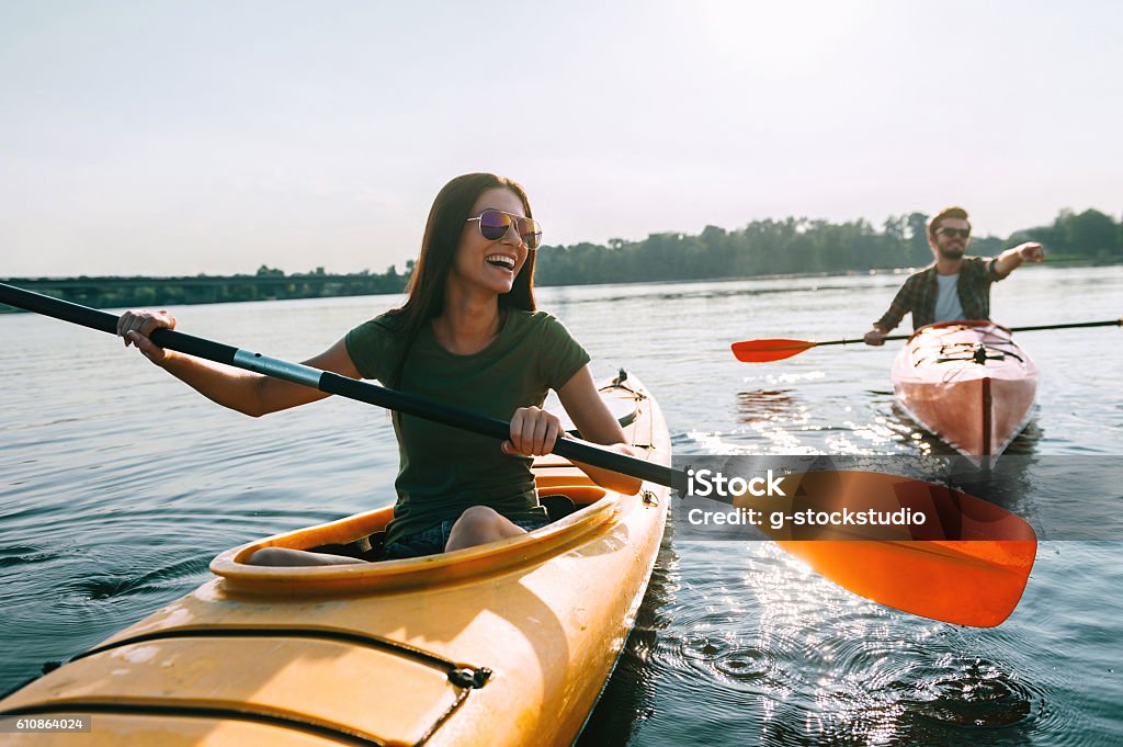 Couple kayaking together. Beautiful young couple kayaking on lake together and smiling Kayaking Stock Photo