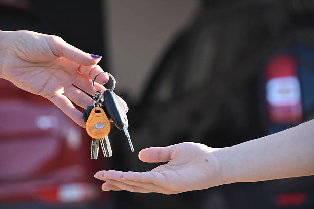 kobieta trzymająca za rękę kluczyk samochodowy - valet parking zdjęcia i obrazy z banku zdjęć