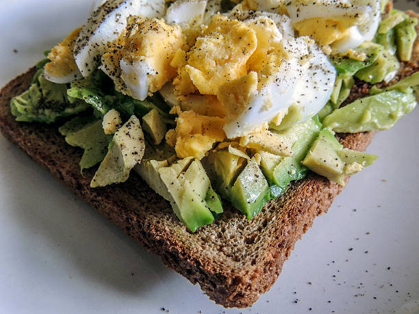 istock Healthy food. Avocado with free range egg on brown bread 610867316