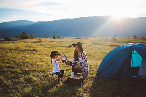 mujer joven acampando con una niña - playing playful baby contemporary fotografías e imágenes de stock