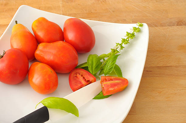 Tomatoes and basil with a ceramic knife