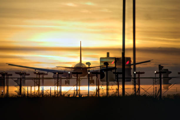 日没二重暴露で飛行機の着陸 - ヒースロー空港 ストックフォトと画像