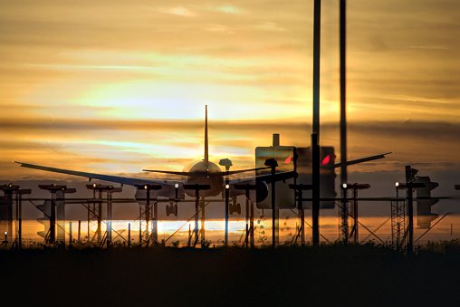 Airplane approaching the landing strip at sunset. Heathrow, London, UK.