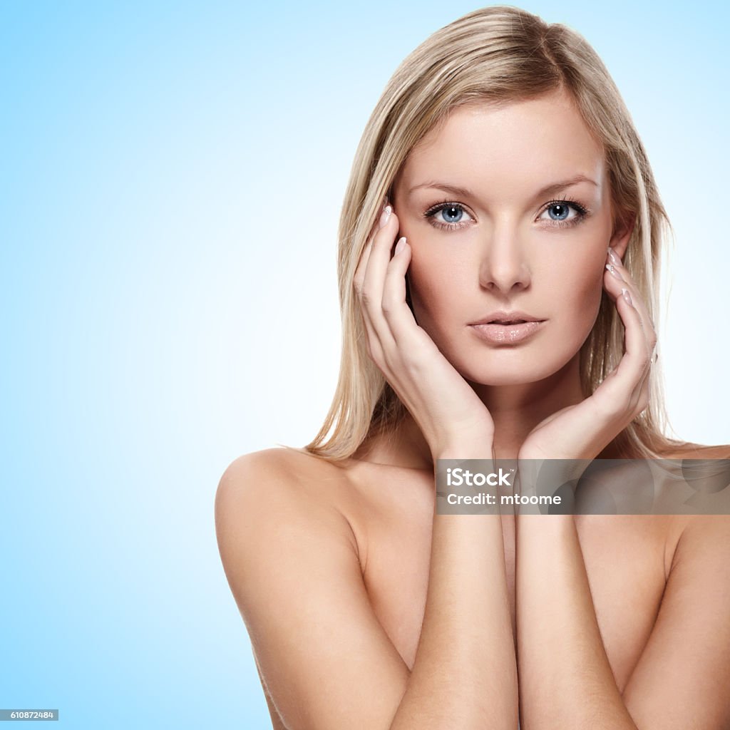 Pure beauty on blue Portrait of beautiful female model on blue background Adult Stock Photo