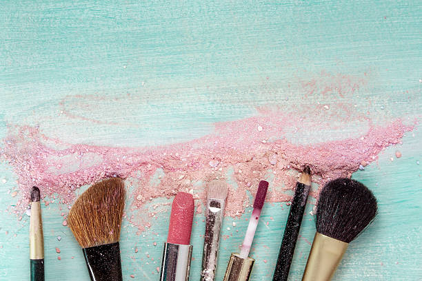 istock Makeup brushes and lipstick on teal blue background 610872608