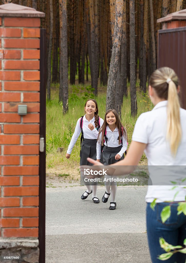 Two cheerful girls running to mother after school - Royalty-free Familie Stockfoto Two cheerful girls running to mother after school - Royalty-free Familie Stockfoto