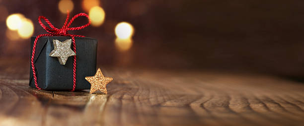 Christmas gift on an empty table Christmas gift and stars on an empty table with bokeh stars in your eyes stock pictures, royalty-free photos & images