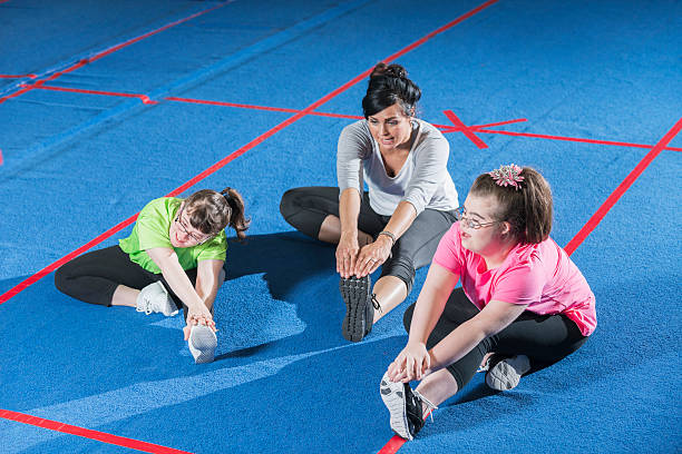 istock Fitness instructor working with special needs girls 610877806