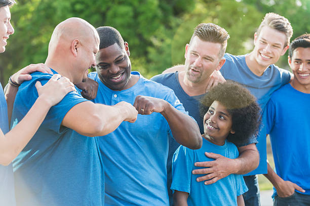 istock Multi-racial group of fathers and sons in blue shirts 610878032