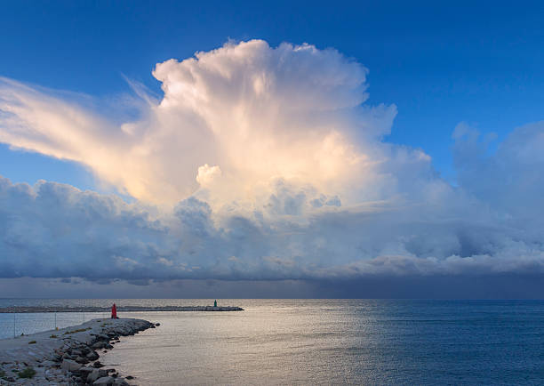Breakwater with headlights dominated by stormy cumulus.