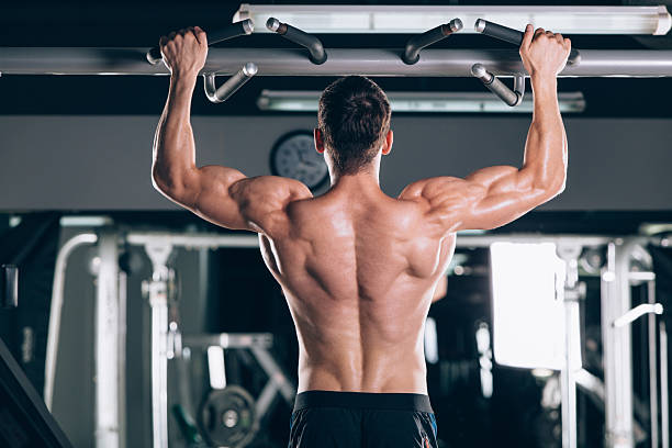 istock Athlete muscular fitness male model pulling up on horizontal bar 610880844