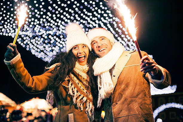 istock Cheerful young couple having fun with sparkling candles at night 610882592