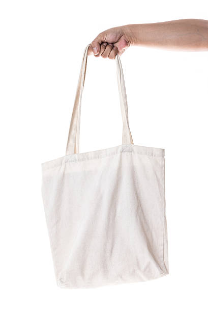 istock Hand holding cotton eco bag on white background 610882640