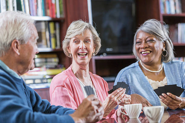 istock Multiracial group of seniors talking, playing card game 610883484