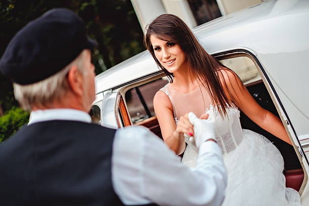 istock Driver helping bride to get out of the car 610884290