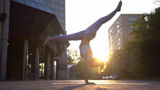Young Woman Doing Yoga Meditation Exercises at Sunset
