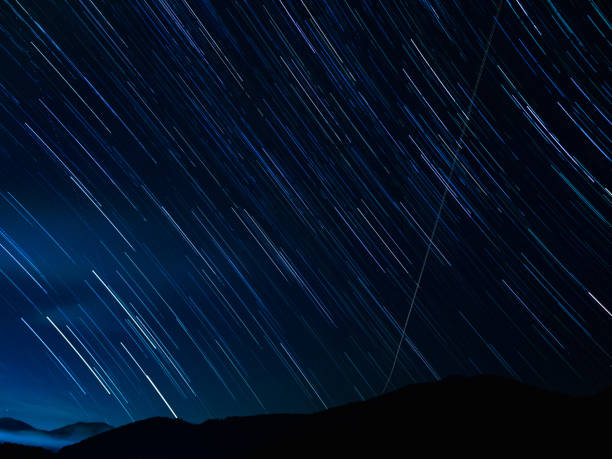 Star trails with night mountain ridge stock photo