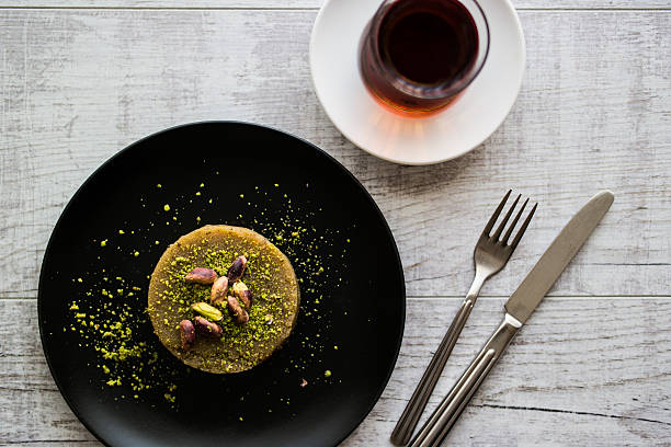 istock Turkish Dessert irmik helvasi with pistachio powder and tea. 610944404