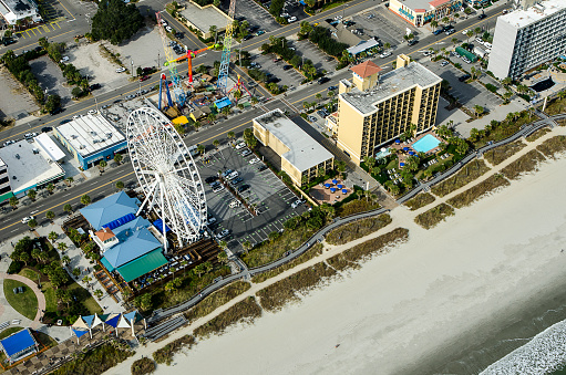 Aerial View of the oceanfront Skywheel, Pier and Boardwalk, restaurants, condominiums, resorts and hotels along the Grand Strand of Myrtle Beach, South Carolina. All logos have been removed.