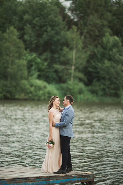 istock Bride and groom walking on the river, smiling, kissing 610947334