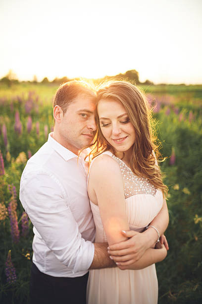 istock Emotional beautiful bride hugging newlywed groom from behind sunset at 610947802